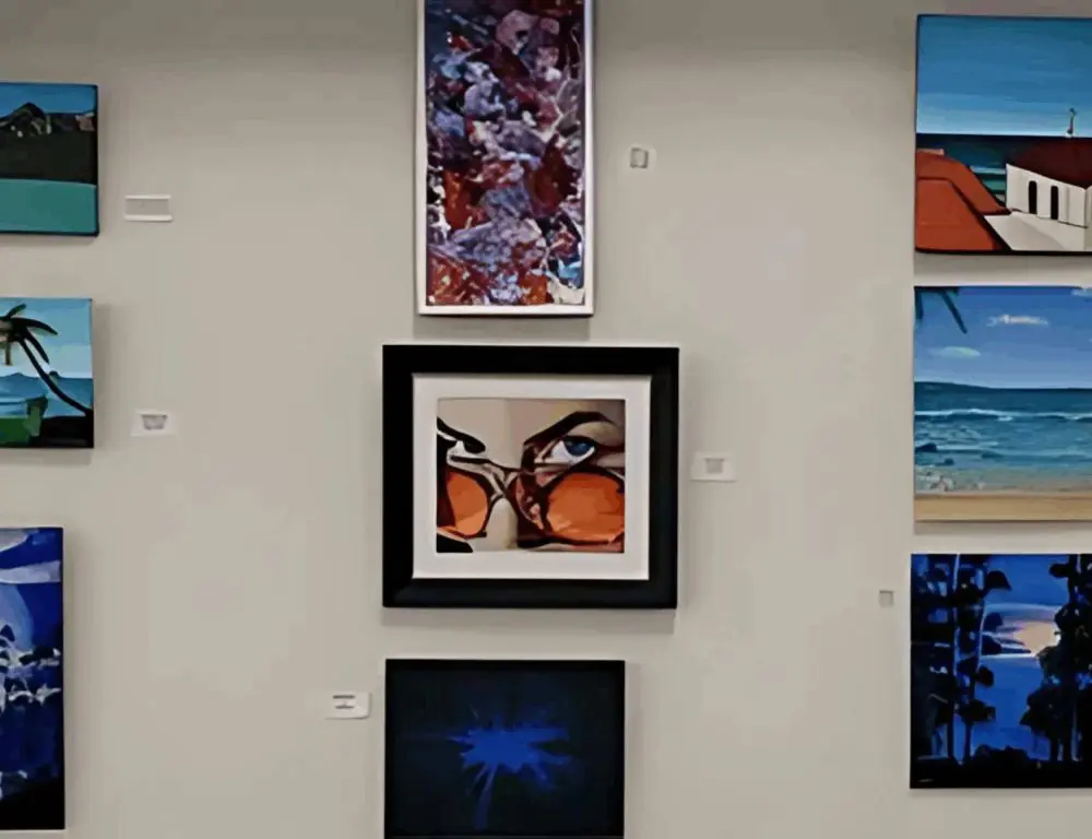 A gallery wall displaying various framed artworks, including abstract designs and landscapes.